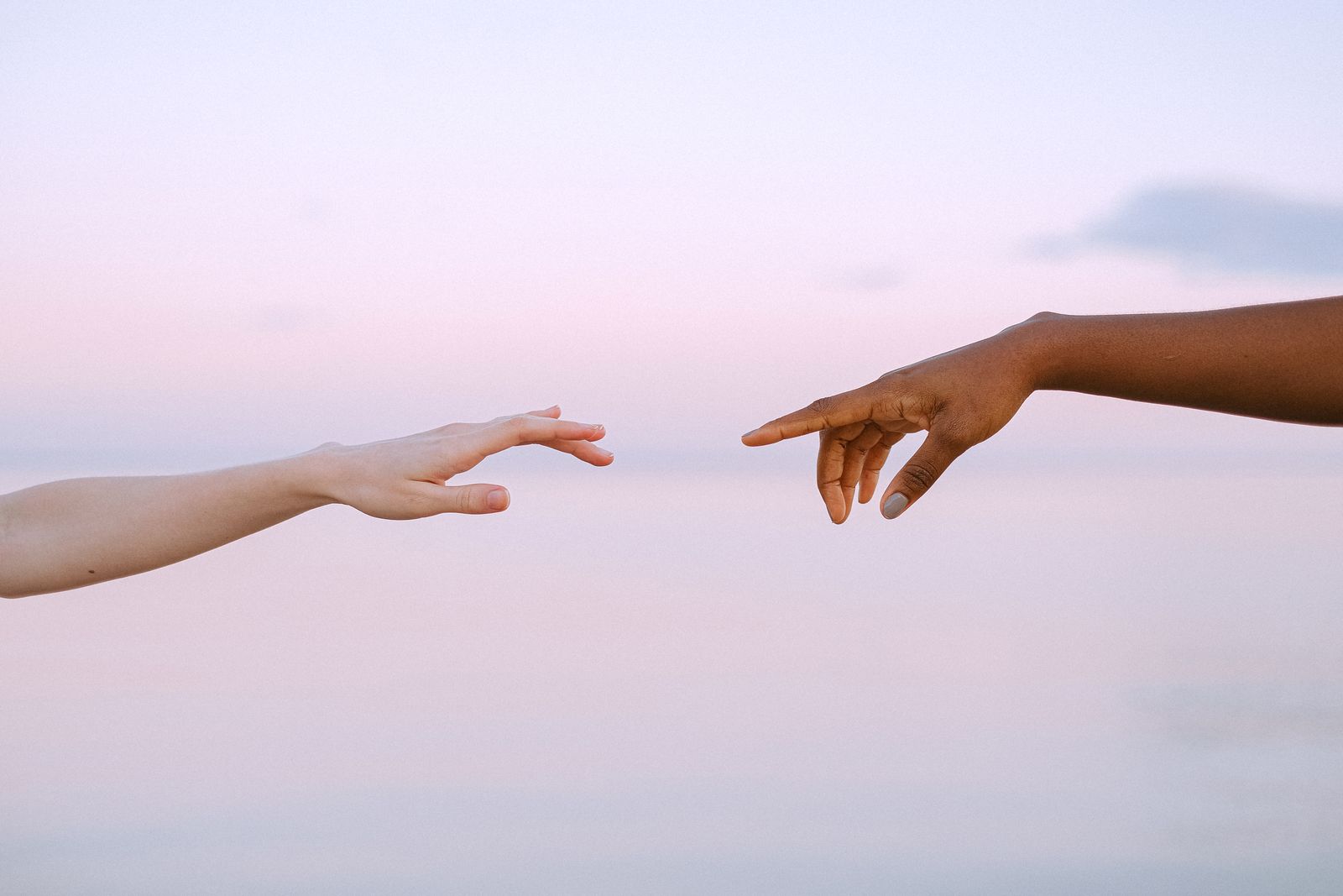 Two people reaching out and joining hands in support